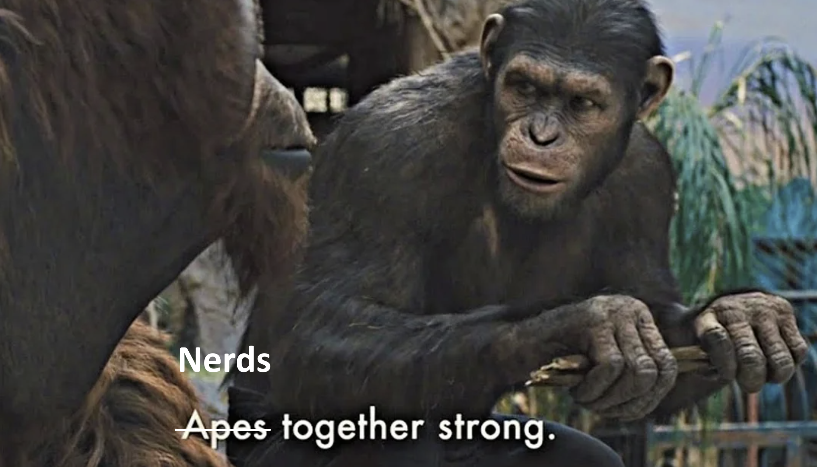 A still from the film Rise of the Planet of the Apes, showing a chimpanzee saying 'Apes together strong'. The word 'Apes' is crossed out a replaced with 'Nerds'.