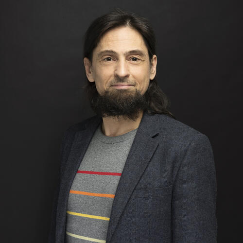 Profile photo of Chris, bearded and jacketed.