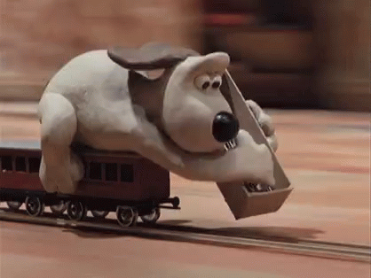 Gromit laying train tracks down before a fast moving train.
